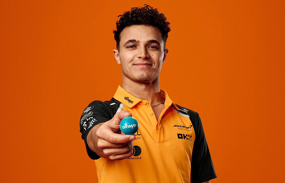 McLarenin asussa oleva Lando Norris pitää kädessään Allwyn lottopalloa.
