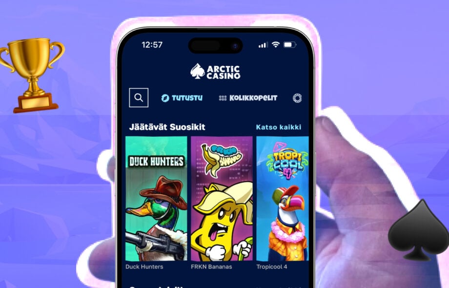 Älypuhelimen näyttö, jossa Arctic Casinon etusivu. Ruudulla näkyy ‘Jäätävät Suosikit’ -kategoriassa pelejä, kuten Duck Hunters, FRKN Bananas ja Tropicool 4. Vieressä pokaalin ja Arctic Casinon patasymbolin ikoni.