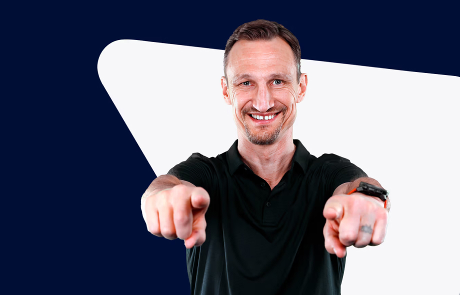 Sami Hyypiä hymyilee Veikkauksen grafiikoiden edessä.