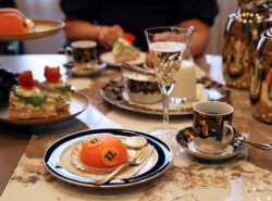 Veikkauksen juhlavalta näyttävää tarjoilua miljonääreille voittajakabinetissa. Kuvassa näyttää olevan samppanjaa, kakkua mikä on lottopallon muotoinen ja kahvia.