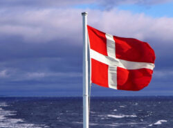 Tanskan lippu ja Rahapelisanomien liilan väristä taustaa.