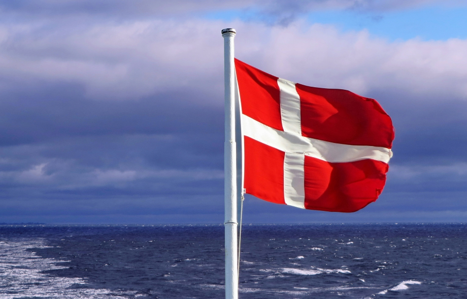 Tanskan lippu ja Rahapelisanomien liilan väristä taustaa.