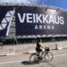 Kuvassa Veikkaus Arena Helsingissä. Veikkauksen mainoskylttiä vielä asennetaan. Etualalla pyöräilijä.