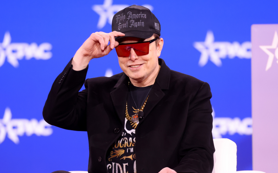 Elon Musk lavalla kuvassa, päällään Amerikka-aiheinen lippis ja paita.