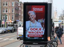Vanhempi nainen esittelee Circus.nl nettikasinoa katumainoksessa Amsterdamissa.