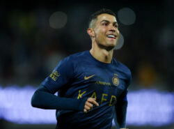 Ronaldo hymyilee Saudi-Arabialaisen jalkapallojoukkueen paidassa.