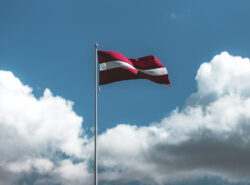 Latvian lippu liehuu taivasta vasten