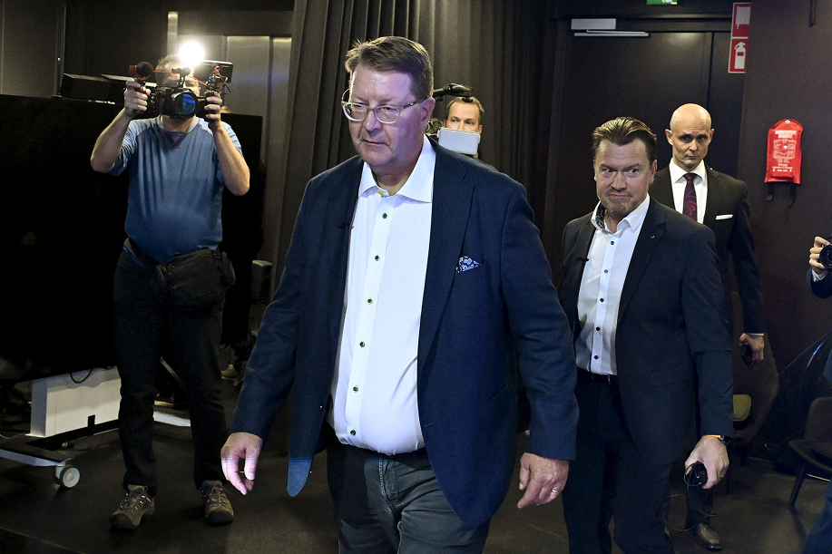 Miehet kävelevät lehdistötilaisuuteen