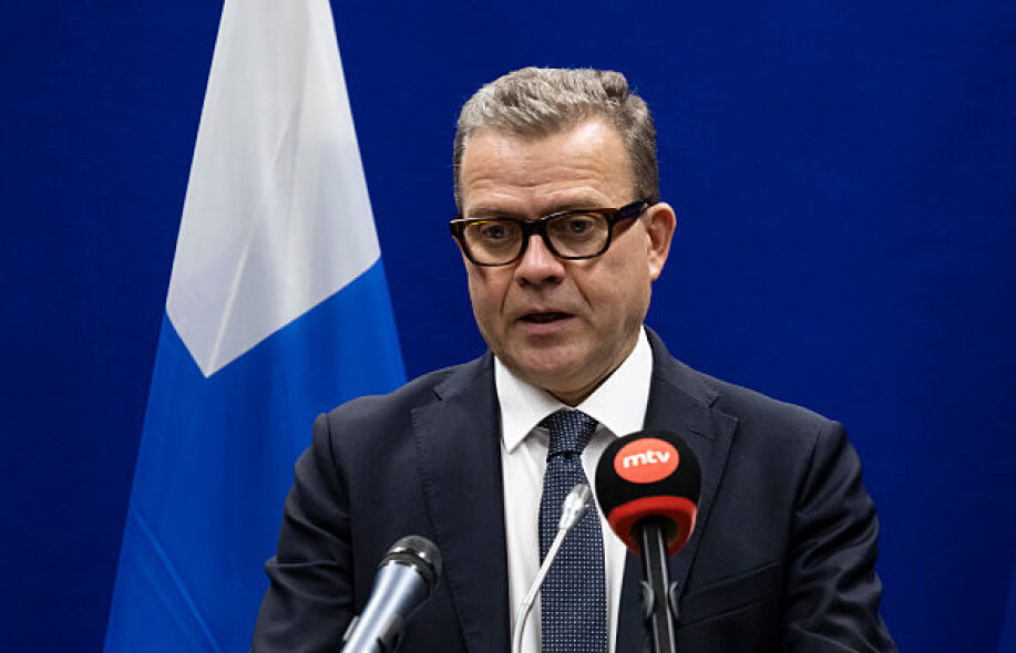 Kuvassa Petteri Orpo. Taustalla Suomen lippu ja edessä MTV3 mikrofoni.