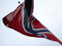 Norjan lippu liehuu vaaleaa taivasta vasten.