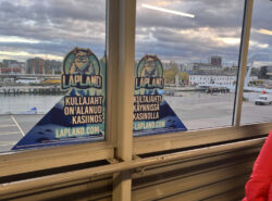 Etualalla laivaterminaalissa Lapland Kasino mainos, taustalla Tallinnaa.