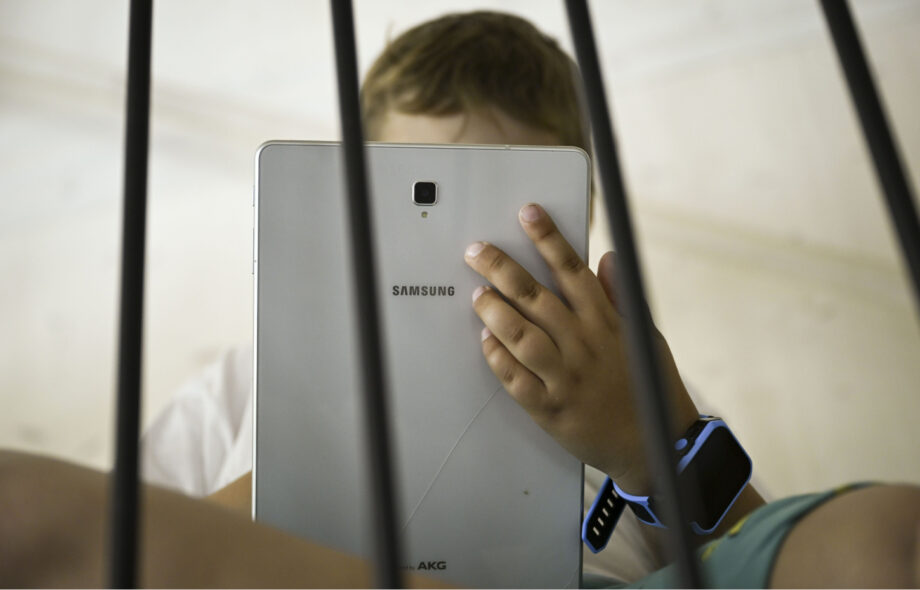 Lapsi käyttää tablettia.