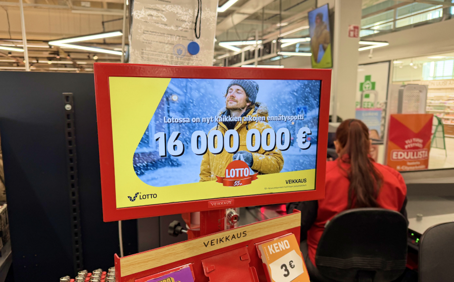 Kuvassa Veikkaus mainoskyltti kaupassa kertoo että päivän Lotto-arvonta pitää sisällään 16 miljoonan euron päävoiton.