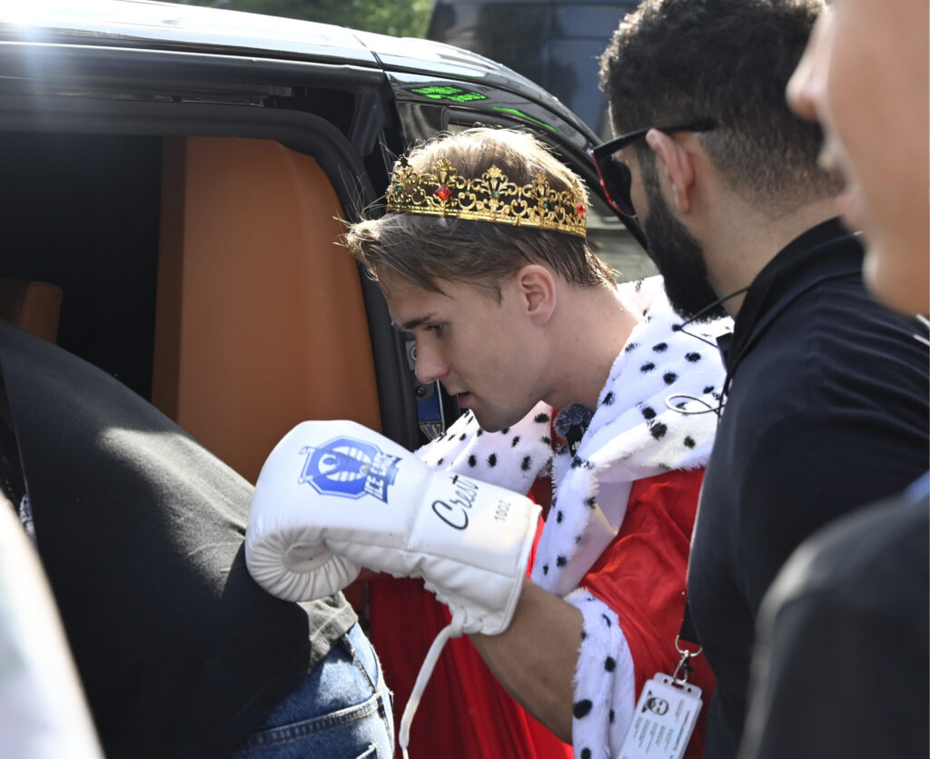 Stagala nouisemassa auton takapenkille Ice Cage nyrkkeilyhanskat kädessään.