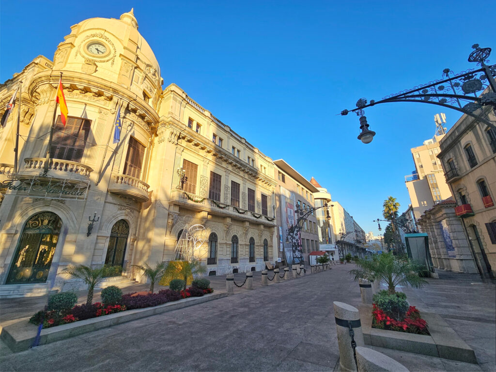 Espanjalaiselta näyttävä kävelykatu. Rakennuksen lipputangoissa näkyy Ceutan, Espanjan ja Euroopan liput.