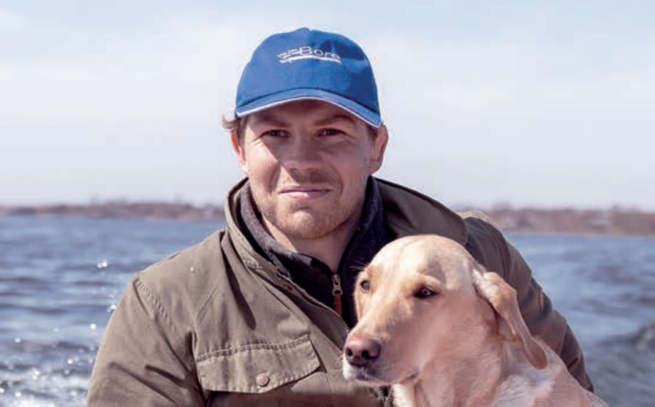 Christer Fahlstedt kuvattuna Ahvenanmaan saaristomaisemassa koiran kanssa.