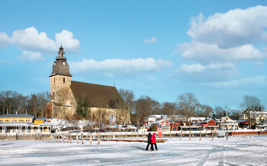 Talvimaisemaa Naantalissa. Ihmiset kävelevät jäällä. Taustalla Naantalin kirkko ja satamaa.