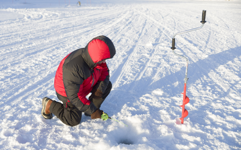 Mies pilkkii Ivalojoella.