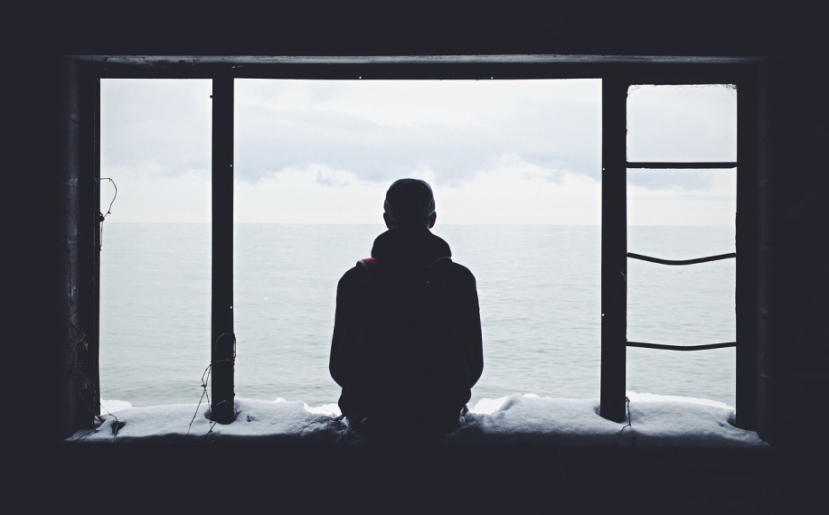 Henkilö istuu merimaiseman edessä. Kuvastaa meditaatiota.