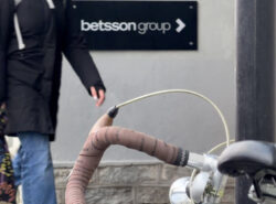 Ihminen kävelee Betsson Group toimistolle osoittavan kyltin ohi Tallinnassa. Etualalla Nishiki Continental touringpyörä vuodelta 1983.