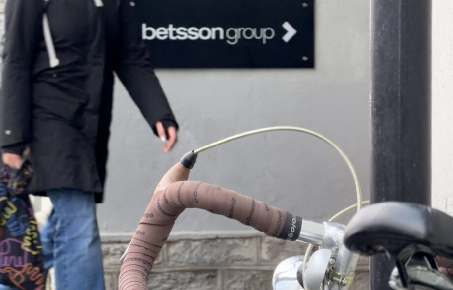 Ihminen kävelee Betsson Group toimistolle osoittavan kyltin ohi Tallinnassa. Etualalla Nishiki Continental touringpyörä vuodelta 1983.