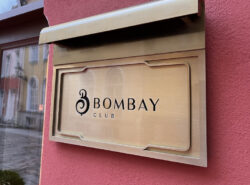 Bombay Club kyltti Tallinan vanhassakaupungissa Rataskaevu kadulla. Kultainen kyltti ja punertava talo. Vieressä näkyy kasinon ovi.