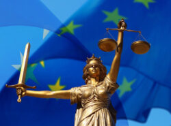 Oikeutta kuvaava naispatsas EU lipun edessä. Hieman abstraktin näköinen.