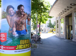 Eurojackpot-katumainos luo mielikuvaa rantalomasta ja kauniista naisisista. Mainos mainitsee että todennäköisyys voittoon on 1:140000000.