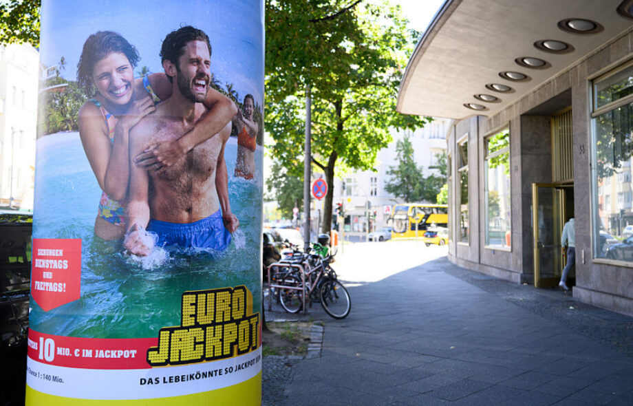 Eurojackpot-katumainos luo mielikuvaa rantalomasta ja kauniista naisisista. Mainos mainitsee että todennäköisyys voittoon on 1:140000000.