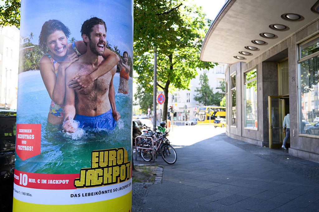 Eurojackpot-katumainos luo mielikuvaa rantalomasta ja kauniista naisisista. Mainos mainitsee että todennäköisyys voittoon on 1:140000000.