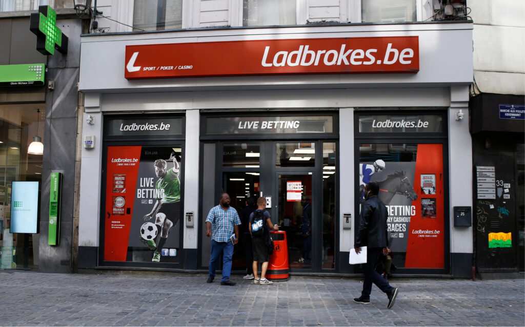 Ladbrokes-vedonlyöntiliikkeen julkisivu Belgiassa, jossa ikkunoissa näkyy rahapelimainontaa ja urheiluteemaisia vedonlyöntijulisteita.
