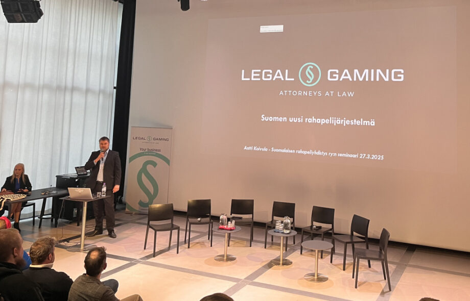 Kuvassa käynnissä Suomen rahapeliyhdistyksen järjestämä keskustelutilaisuus Oodi-kirjastossa. Lavalla Antti Koivula ja Minna Ripatti. Ruudulla "Legal Gaming" logo. Ja otsikko "Suomen uusi rahapelijärjestelmä".