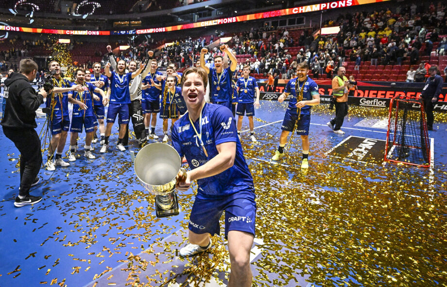Suomen Justus Kainulainen juhlii pokaalin kanssa voiton jälkeen Ruotsin ja Suomen välisessä finaalissa miesten salibandy-maailmanmestaruuskisoissa 2024. Olkapäässä näkyy Veikkaus logo.