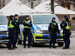 Kuusi ruotsalaista poliisia autojensa edessä.