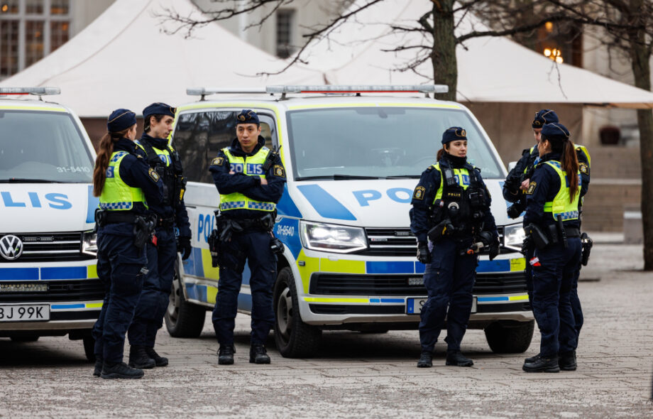 Kuusi ruotsalaista poliisia autojensa edessä.