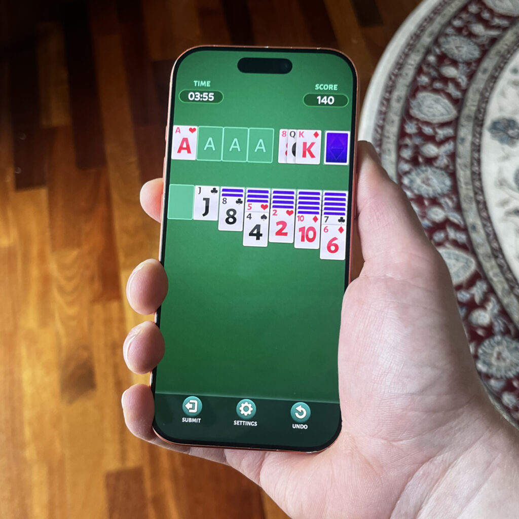 Puhelimen ruudulla pasianssi. Yläpalkissa aikarajoitus ja pistemäärä.