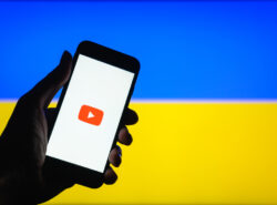Youtube logo puhelimessa, taustalla Ukrainan lipun värit.