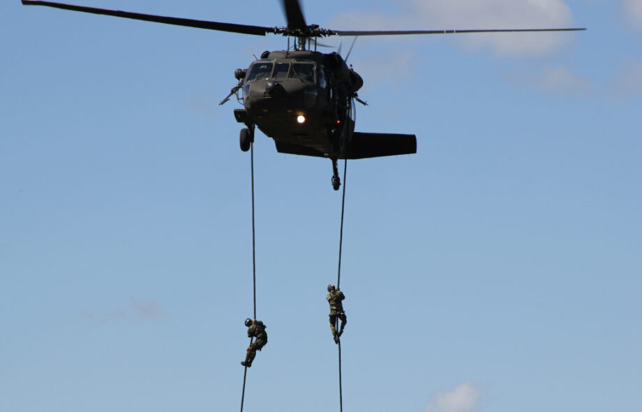 Kaksi sotilasta laskeutuu köyden varassa helikopterista.