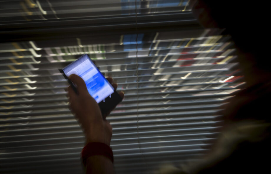 Mies kirjautuu puhelimella Twitteriin.