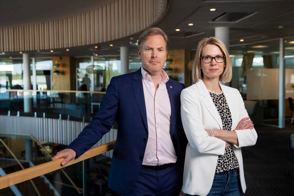 Fahlstedt ja Johansson avarassa ja valoisassa Pafin konttorissa. Materiaalit lasia, puuta ja valkoiseksi maalattuja betonipylväitä.