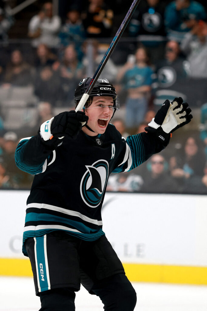 Macklin Celebrini juhlii San Jose Sharks pelipaita päällään.