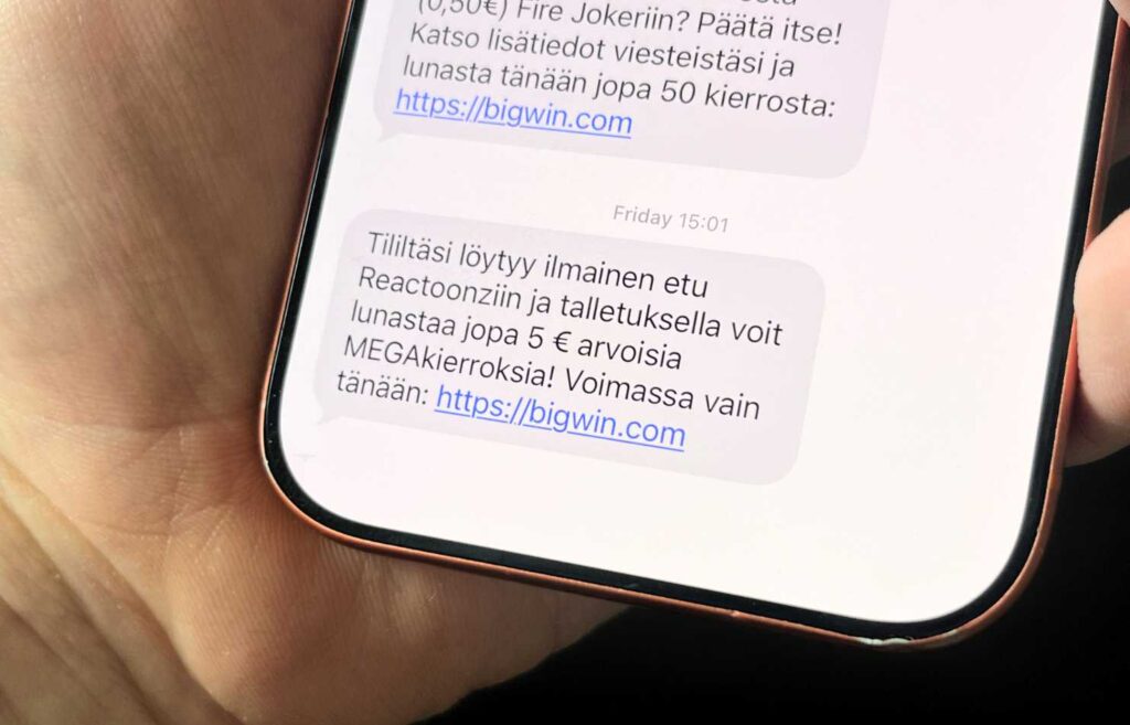 Kuvassa käsi jossa puhelin ja Bigwin kasinolta tullut viesti ilmaisikierroksista Reactoonz peliin. Yleisimmät ilmaiskierrokset ilman talletusta Rahapelisanomat 