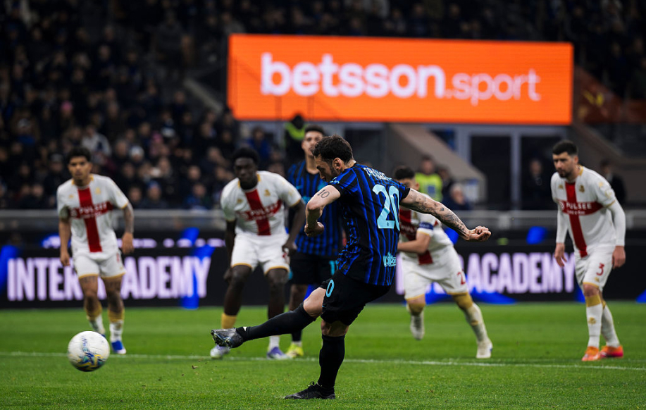 Betsson-sport mainos näkyy jalakapallotähtien takana. Etualan tatuoitu mies tykittää palloa.