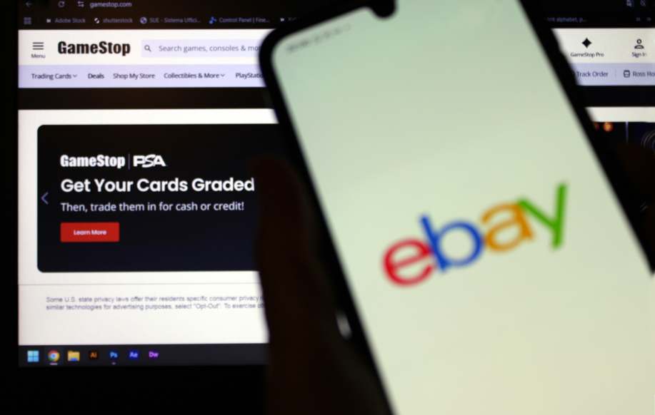 Ebayn logo puhelimessa, taustalla Gamestop-verkkosivu vihjaa että heidän kauttaan voi arvioida keräilykorttien kunnon ja myydä ne.