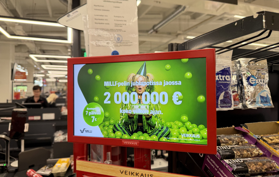 Salon K-Citymarket kassalla Milli-pelin kahden miljoonan euron pottia ja 7-päivän kestotilausta 7€ mainostava digitaalinen kyltti.