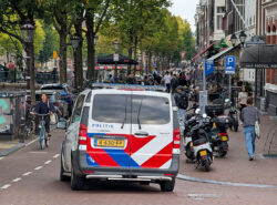 Poliisi auto ajaa pienelle rantatielle Amsterdamin kaupungissa