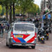Poliisi auto ajaa pienelle rantatielle Amsterdamin kaupungissa