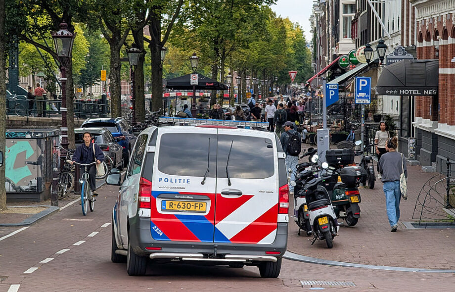 Poliisi auto ajaa pienelle rantatielle Amsterdamin kaupungissa