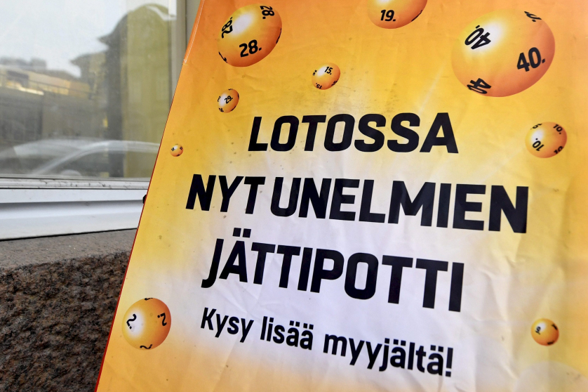 Kadulla ajattomalta näyttävä kyltti kertoo lotossa olevan unelmien jättipotti. Kehottaa kysymään lisää myyjältä.