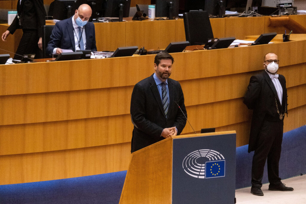 Lukas Mandl puhuu EU puhujapöntöllä. Taustalla puhehenkilörivistössä ja sen edustalla maskit päällä.